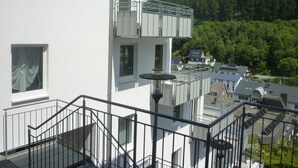 A white building with a balcony and a staircase leading to an upper floor. - Holiday Home in the Centre of Willingen With View (Willingen)