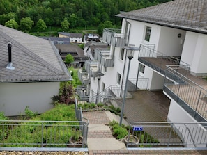 Residents enjoy balconies with outdoor space and a peaceful courtyard setting amidst lush greenery.