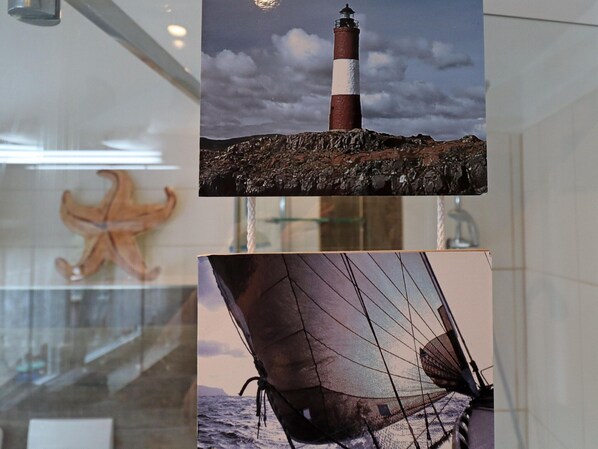 A glass display case with a starfish and a sailboat.