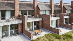 A modern building with multiple balconies, large windows, and a flat roof. - 4 Person Holiday Home on a Holiday Park in Romo (Rømø)