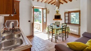 A kitchen with a gas stove, sink, and wooden ceiling beams. - Lavish Holiday Home in Volterra With Pool (Volterra)