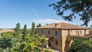 A stone building with a tiled roof, surrounded by lush greenery and trees. - Lavish Holiday Home in Volterra With Pool (Volterra)
