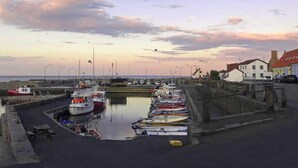 A marina with boats docked, a calm water body, and a sunset sky. - 4 Person Holiday Home in Svaneke (Svaneke)