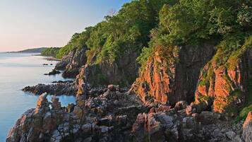 A coastal landscape with rocky cliffs and a calm sea.