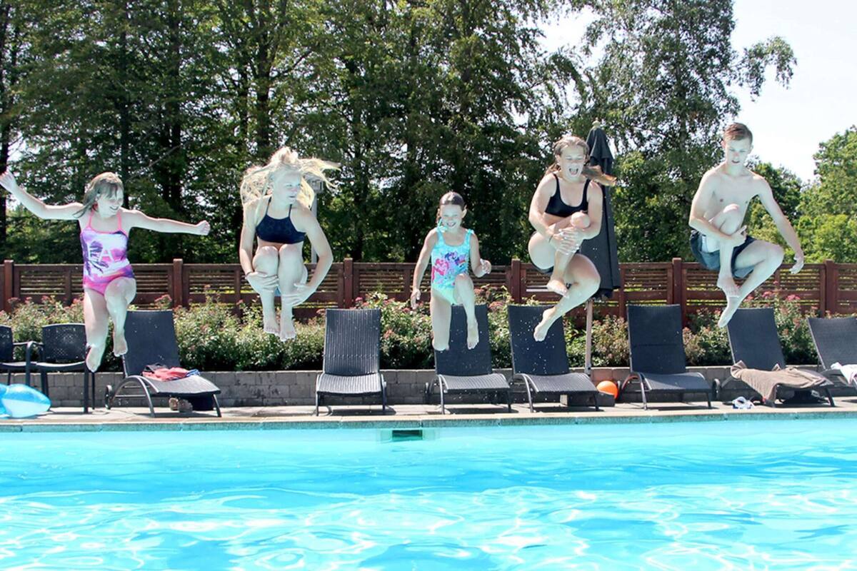 En swimmingpool med fem personer i luften under et hop.