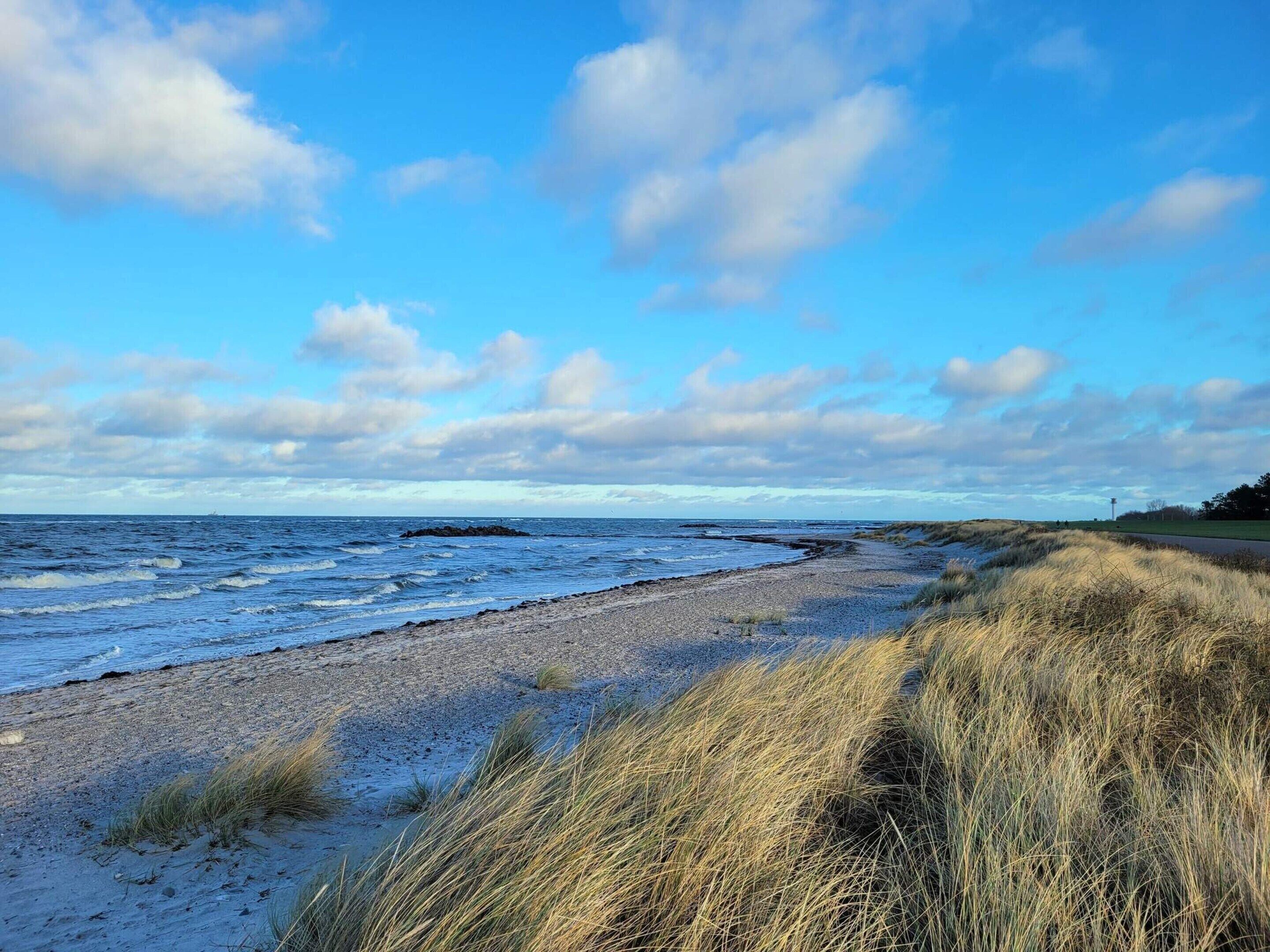 A beach with a clear sky and waves.