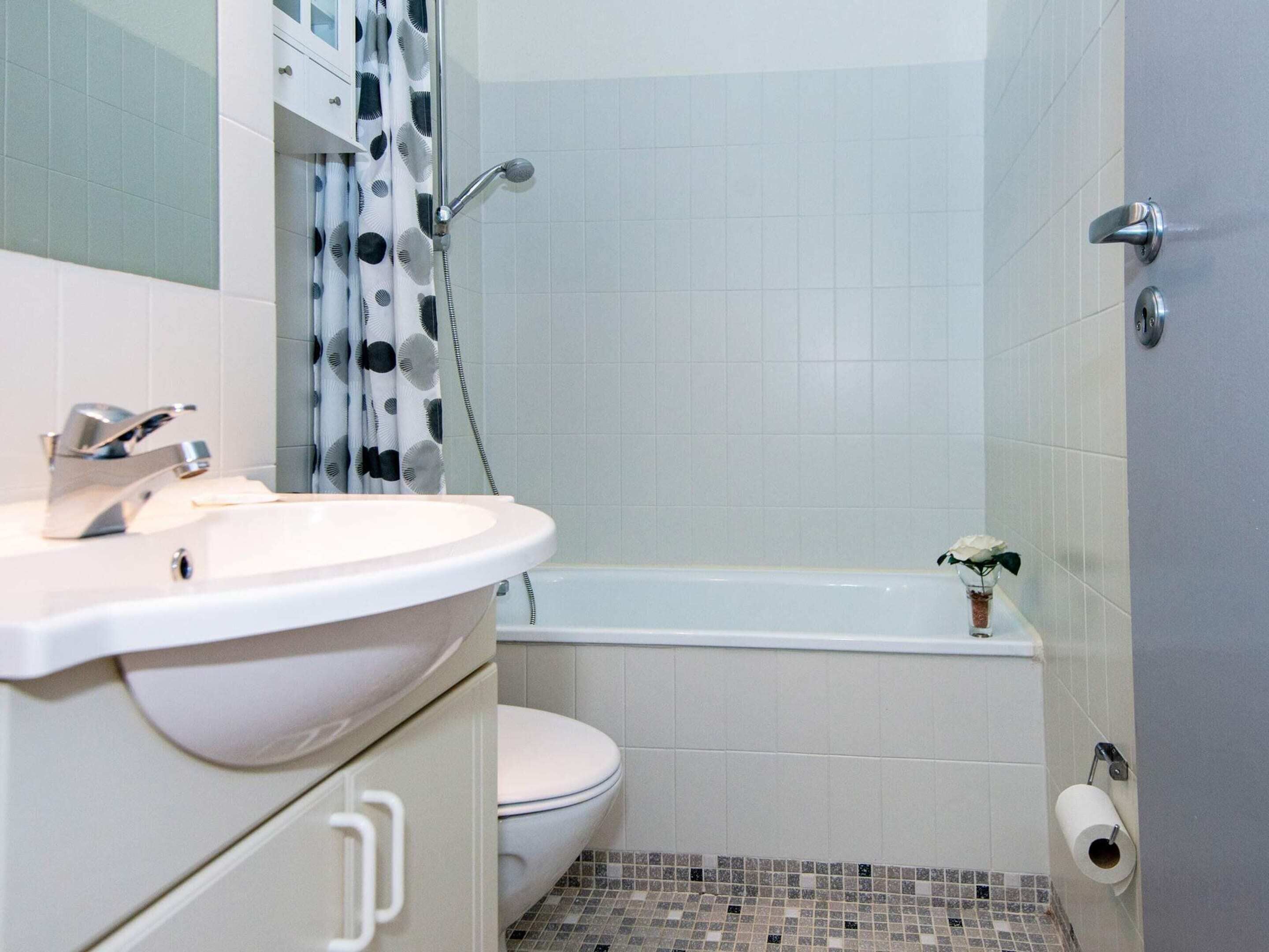 A bathroom with a sink, toilet, and bathtub.