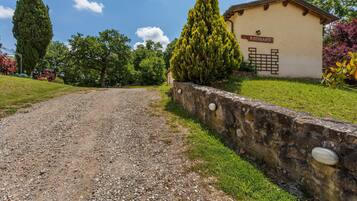 A gravel path leading to a building labeled "RISTORANTE" with a stone wall and greenery.