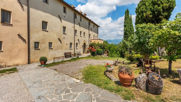 A courtyard with a stone pathway, potted plants, and a building with multiple windows and a door. - Rustic Holiday Home in Citta di Castello With Swimming Pool (Città di Castello)