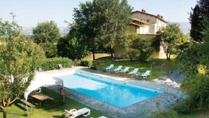 A swimming pool with lounge chairs and a house in the background. - Rustic Holiday Home in Citta di Castello With Swimming Pool (Città di Castello)