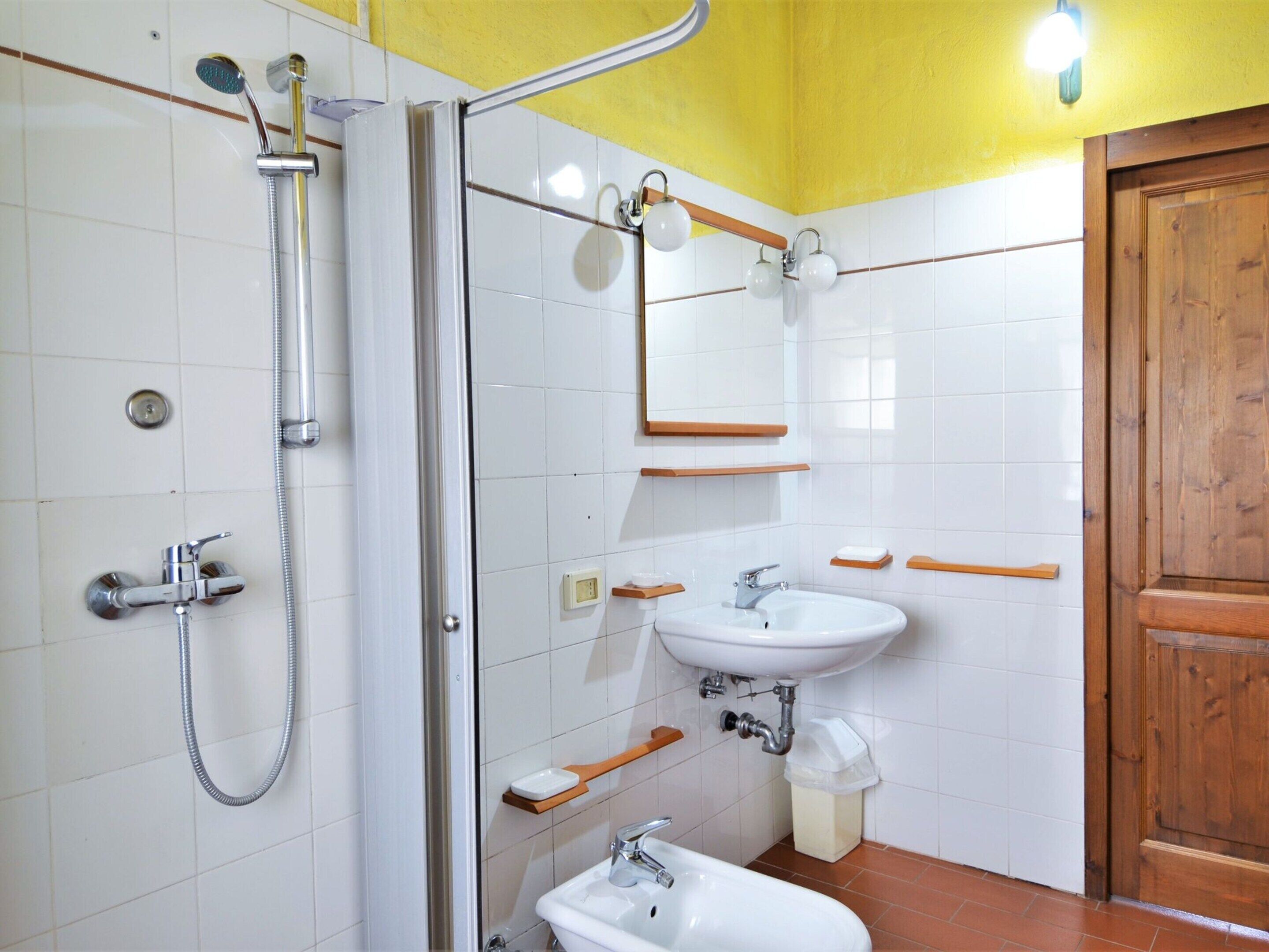 A bathroom with a shower, sink, and mirror.