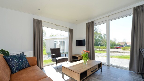 A modern living room with a sofa, coffee table, and TV. - Brand new Chalets at 10 Minutes From the Oosterschelde (Heinkenszand)