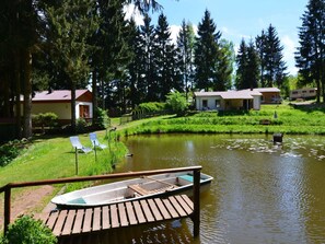 A lakeside property with a dock, a small boat, and a row of houses. - Cosy Apartment With Covered Porch (Friedrichroda)