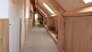 A narrow, wooden hallway with sloped ceilings and skylights, leading to a door at the end. - Pleasant Holiday Home Near the Centre of Haaren (Haaren)
