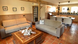 A cozy living room with a sofa, a coffee table with decorative items, and a kitchen area in the background. - Pleasant Holiday Home Near the Centre of Haaren (Haaren)