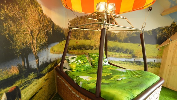 A cozy room with a wicker four-poster bed, a mural of a river and trees, and a hot air balloon decoration. - Pleasant Holiday Home Near the Centre of Haaren (Haaren)