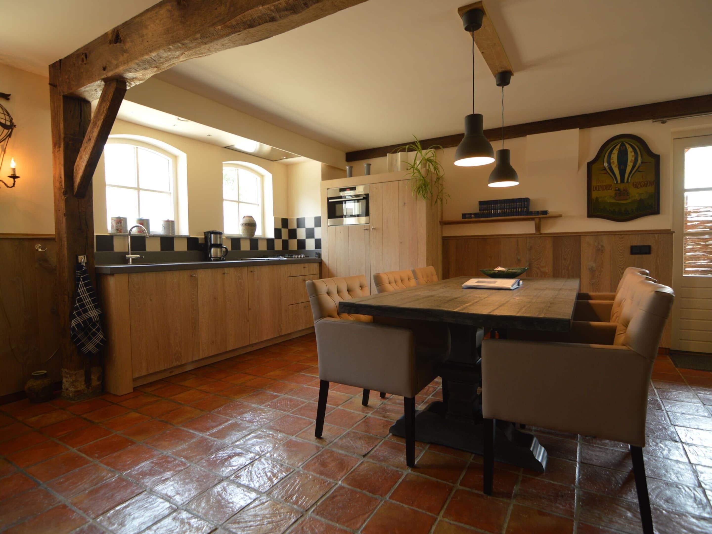 A kitchen with a large island, wooden cabinets, and a dining area with a table and chairs.