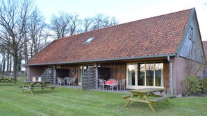 Un bâtiment de style rustique, doté d’un toit en pente, d’une façade en bois et de grandes portes vitrées.