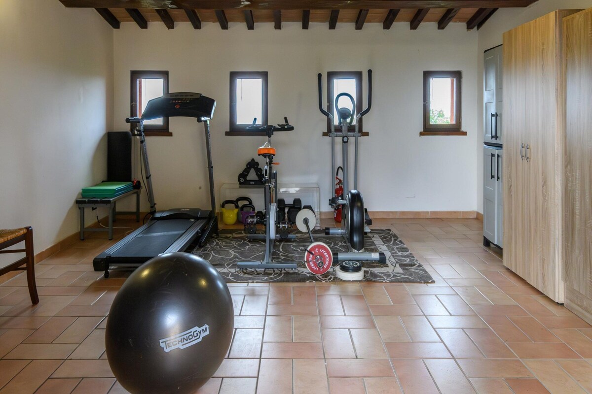 A home gym with exercise equipment, a treadmill, and a weightlifting station.