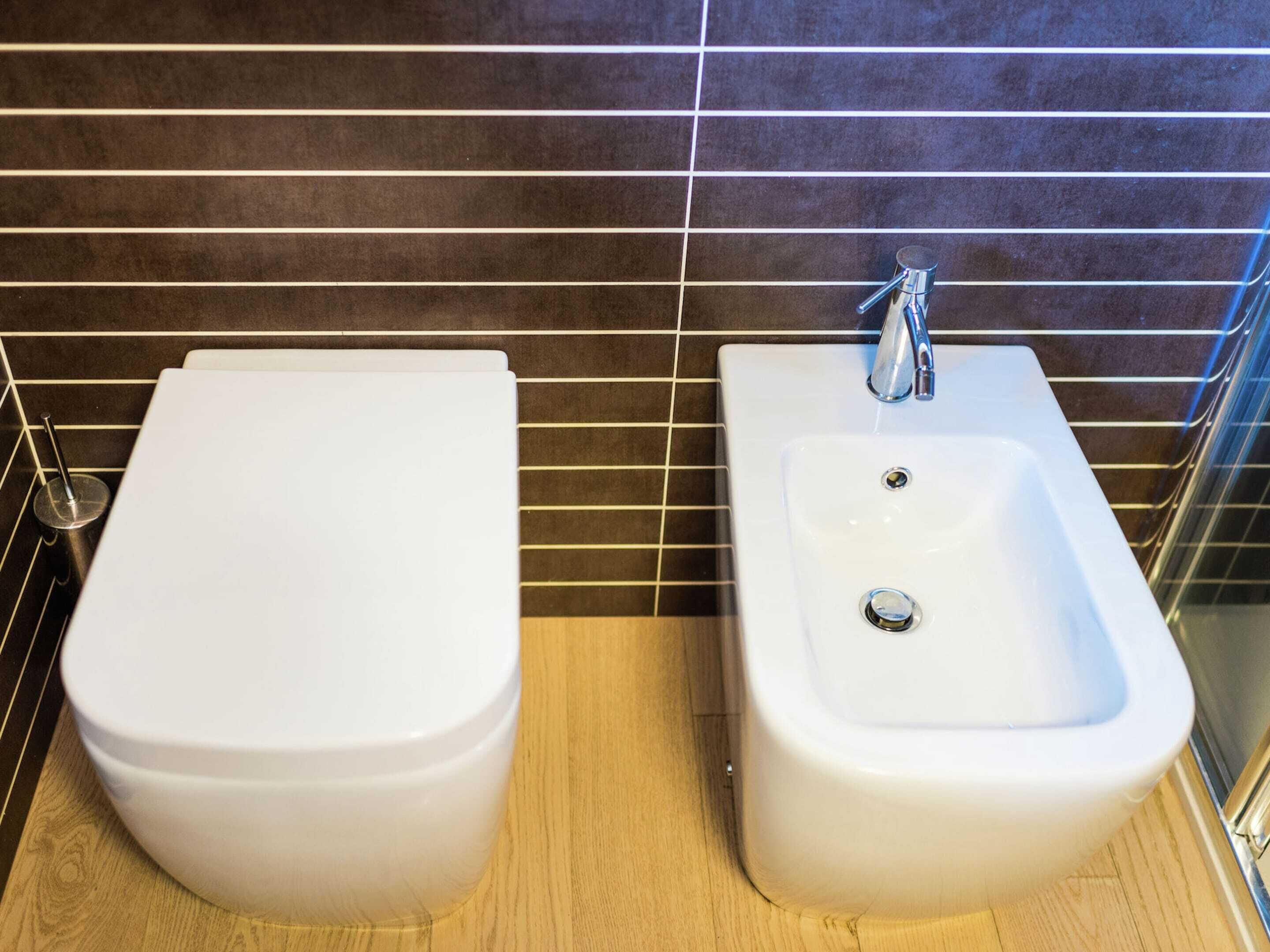 A bathroom with a bidet, a sink, and a toilet.