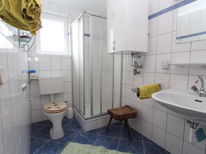 A bathroom with a toilet, shower, sink, and a small stool. - Characterful old Farmhouse With 4 Apartments in Fresach / Carinthia With Garden (Fresach)