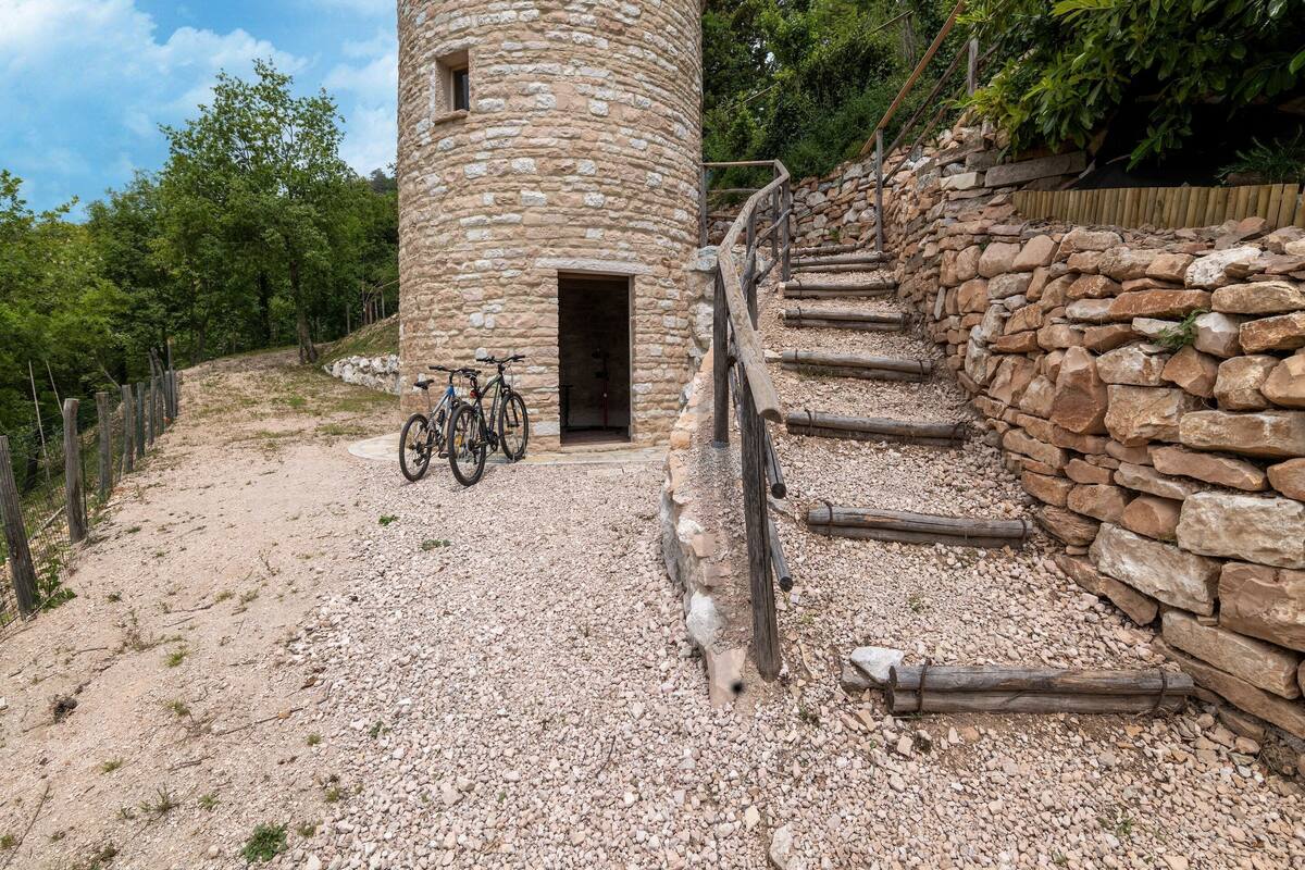 Ein Steinturm mit einer hölzernen Wendeltreppe, die zu einer Tür führt.