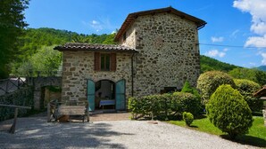 Un edificio de piedra con un pequeño porche y un banco de madera.