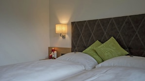 A hotel room with two beds, a nightstand with a lamp, and decorative candles. - Cozy Apartment Near Ski Area in Mayrhofen (Schwendau)