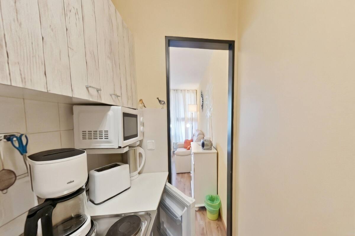 Una cocina con microondas, tostadora y cafetera.