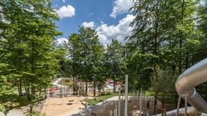 A playground with various play structures, surrounded by trees and a clear sky. - Holiday Apartments in Freyung With Sauna & Swimming Pool (Freyung)
