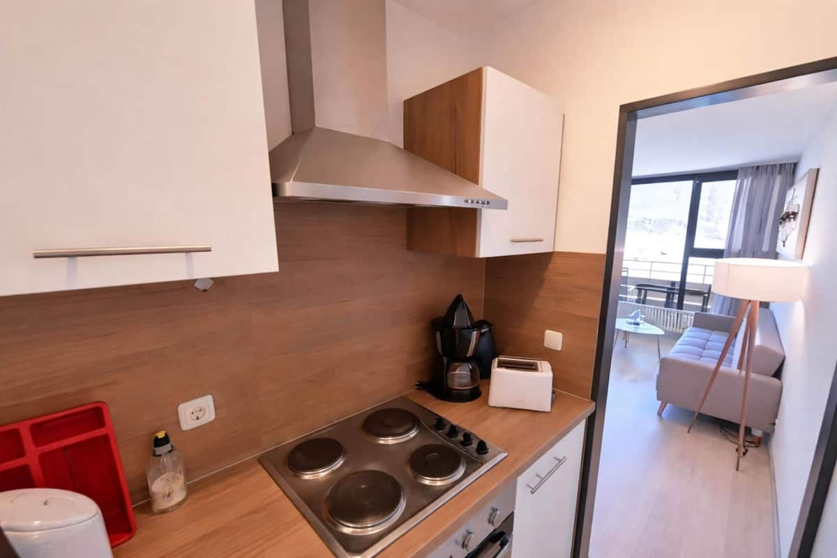 Una cocina moderna con estufa, cafetera y tostadora.
