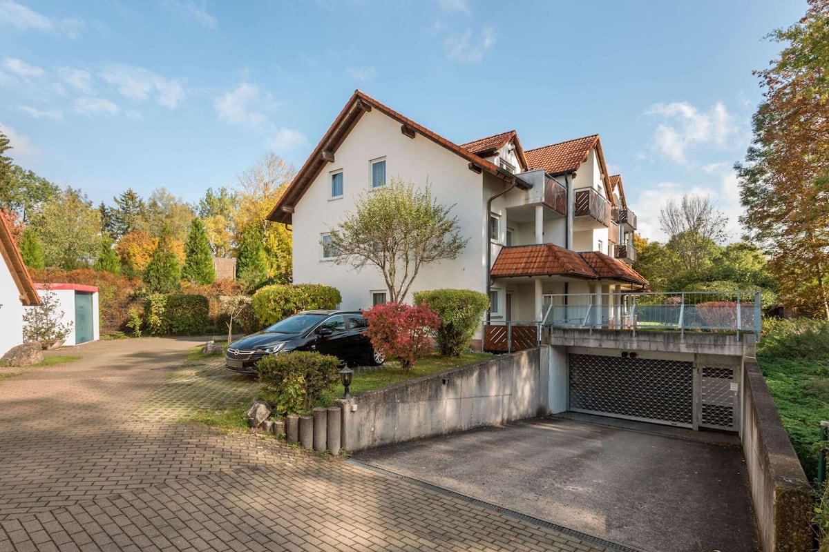Ein zweistöckiges Wohnhaus mit einem Auto auf der Einfahrt.