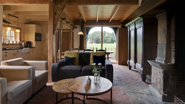 Een gezellig interieur met een eethoek, bank en uitzicht op het omliggende landschap.