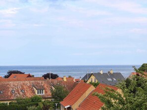 A coastal residential area with houses featuring red-tiled roofs and a view of the sea. - 4 Person Holiday Home in Svaneke (Svaneke)