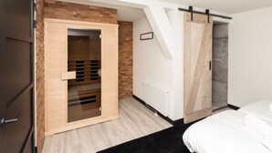 Un dormitorio moderno con un armario de madera, una puerta corredera y una cama.