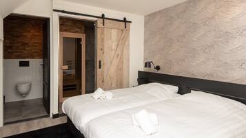 Un dormitorio moderno con una cama grande, una puerta de madera y un papel tapiz estampado.