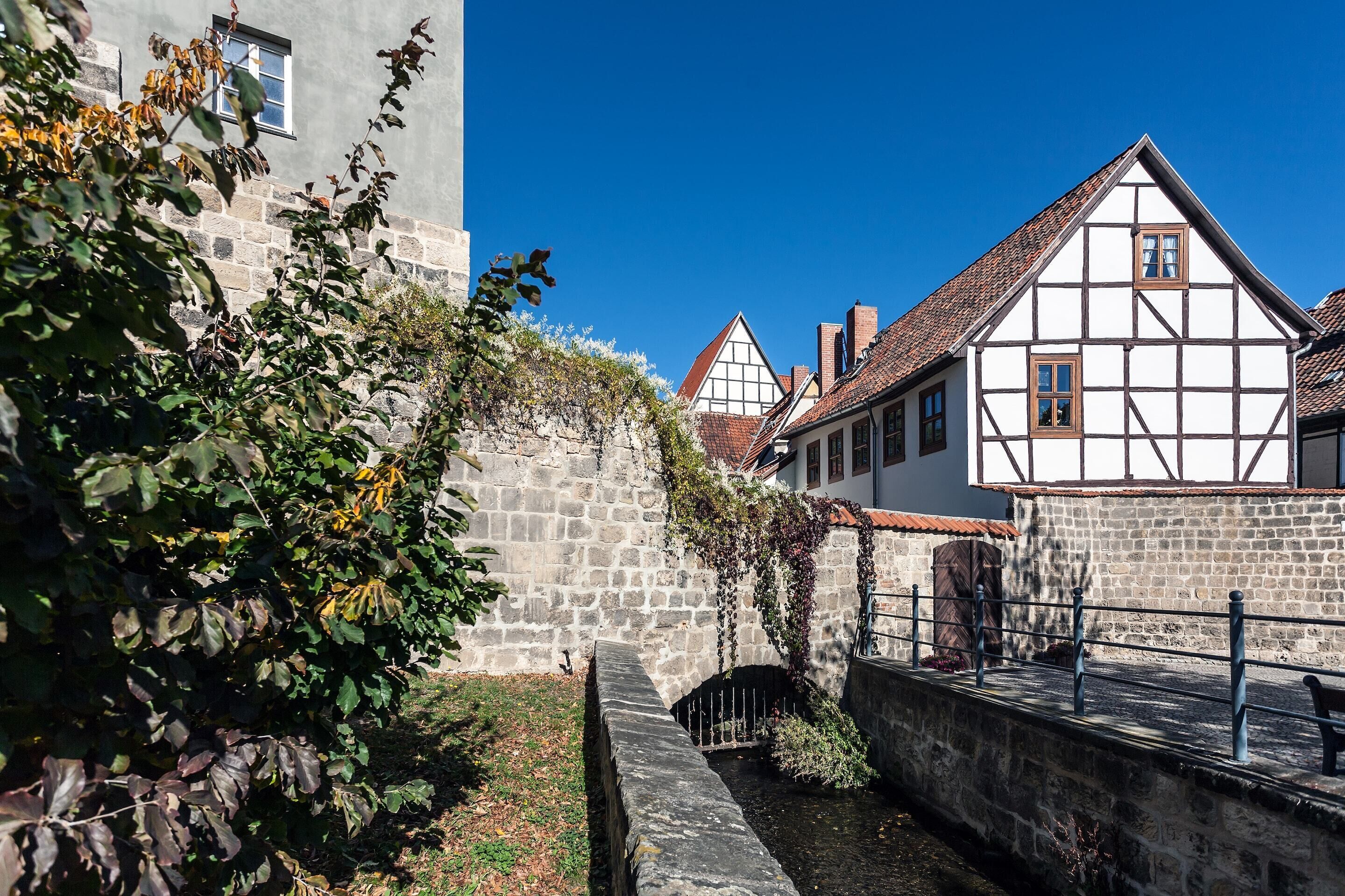 Um edifício histórico com parede de pedra e um estreito canal de água.