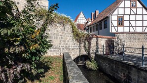 Un edificio histórico de piedra con un estrecho pasaje y un pequeño puente.