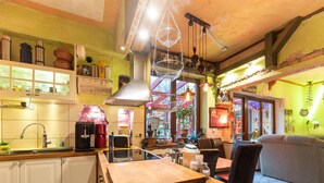 Una cocina acogedora con encimeras de madera, una cafetera y una lámpara colgante.