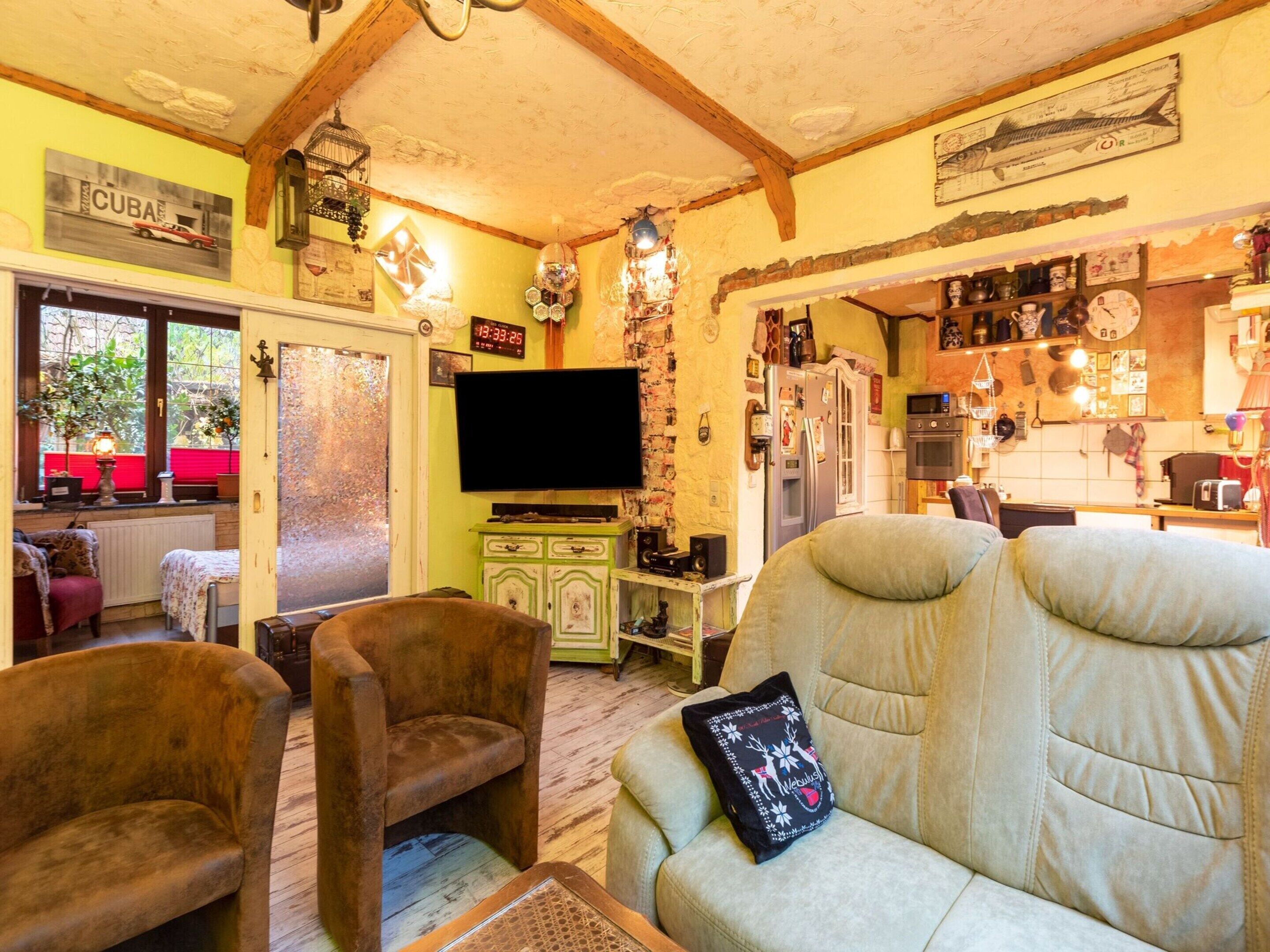 Un salon confortable avec un canapé, des fauteuils et un téléviseur.