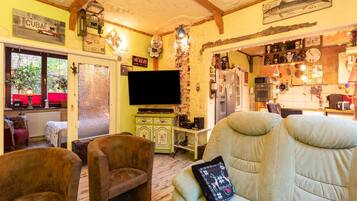 Un salon confortable avec un canapé, des fauteuils et un téléviseur.