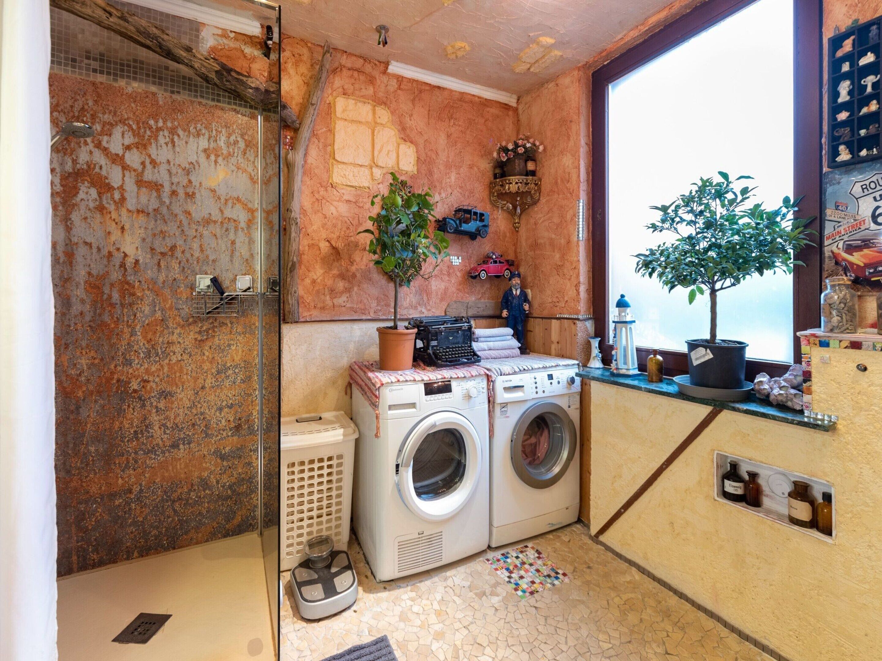 A compact laundry room with a washing machine, dryer, and a small sink.