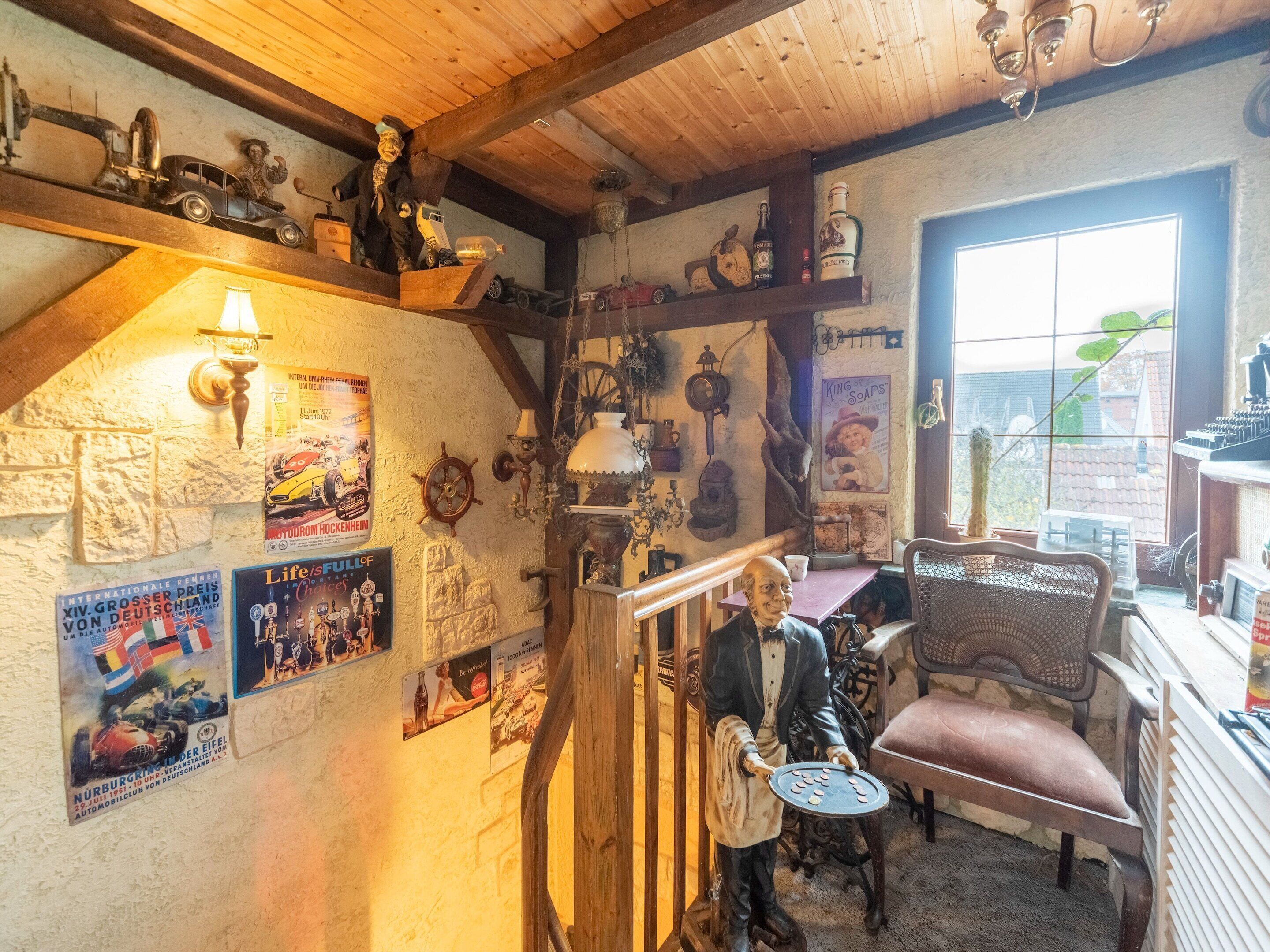 A cozy room with wooden beams, vintage posters, and a variety of collectibles.