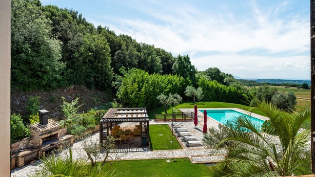 A pool area with a pergola, outdoor seating, and a view of a forested hillside. - Elegant Apartment Only 1 Hour From Rome (Narni)