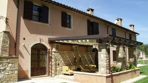 A two-story house with a stone facade, a covered patio with outdoor furniture, and a gated entrance. - Elegant Apartment Only 1 Hour From Rome (Narni)