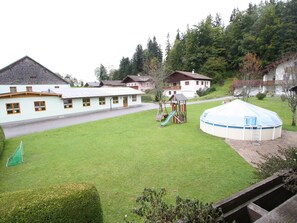 Ein Wohngebiet mit einem großen weißen Haus, einem Spielplatz und einem runden Pool.