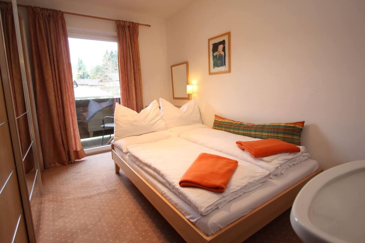 Una camera d'albergo con letto, bagno e finestra con tende.