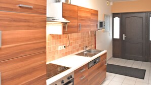 A modern kitchen with wooden cabinets, a stainless steel sink, and a built-in oven.
