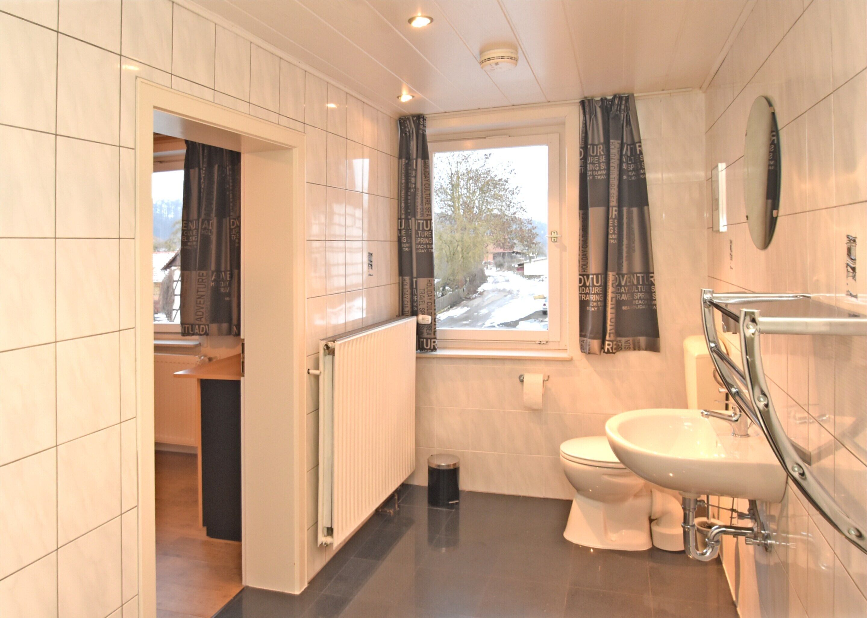 Un baño con inodoro, lavamanos y ventana.