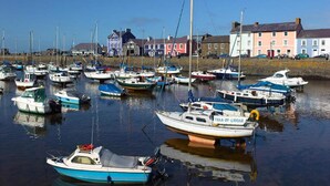 A harbor with various boats docked, a clear sky, and buildings in the background. - Secluded Holiday Home in Ceredigion With Garden (Llanon)